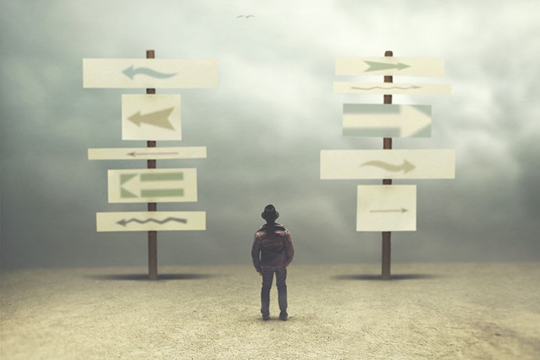 person looking at signs pointing in different directions, illustrating the many contradictory messages, policies and initiatives that universities and their staff are confronted with person looking at signs pointing in different directions, illustrating the many contradictory messages, policies and initiatives that universities and their staff are confronted with