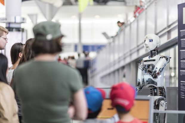 People are listening to the robot introduce itself.